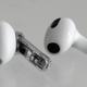 A single Ear (stick) earbud sitting next to a single third-gen AirPod earbud.